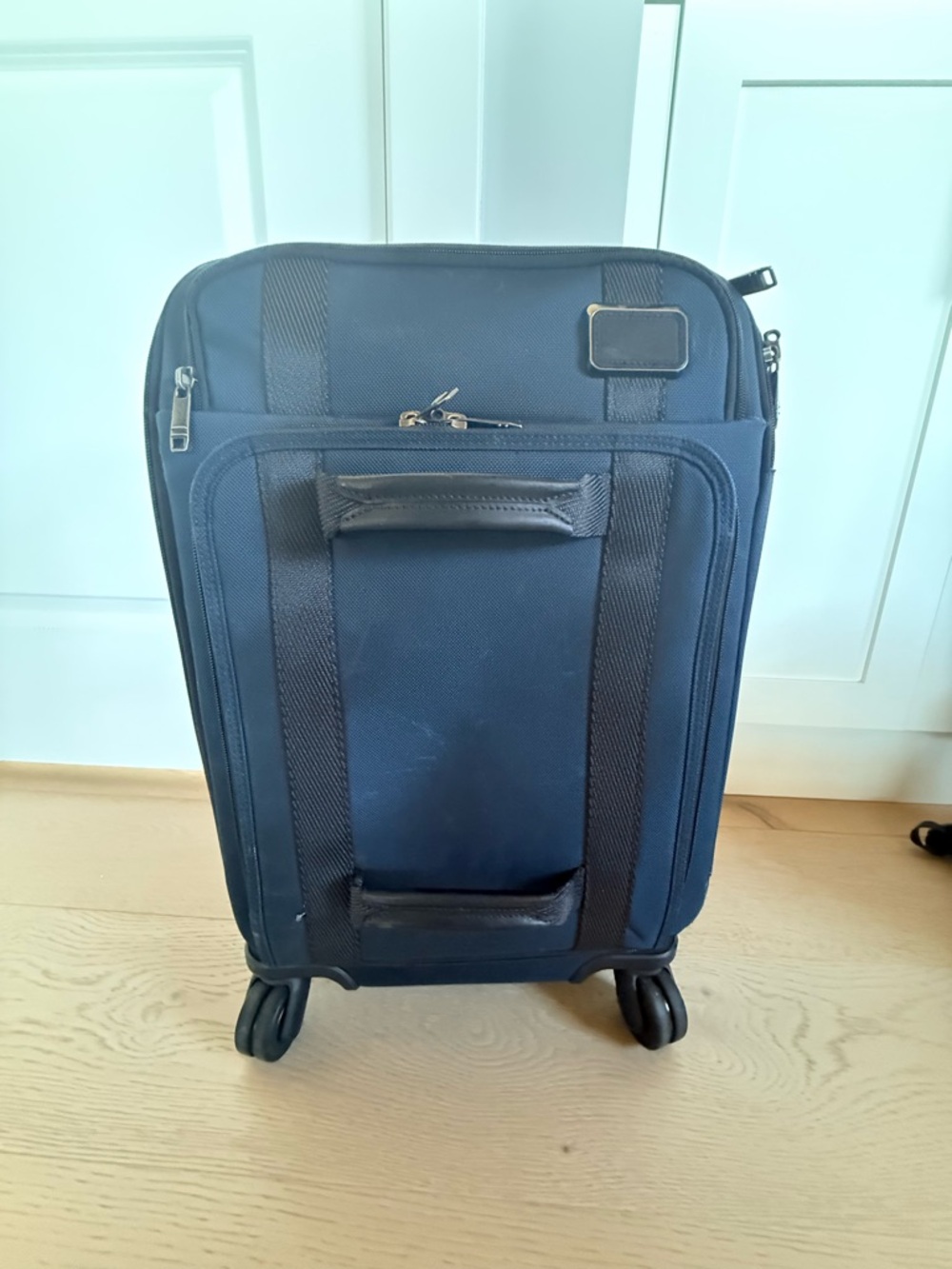 TUMI Merge International Front Lid 4-Wheeled Carry-On in navy blue.